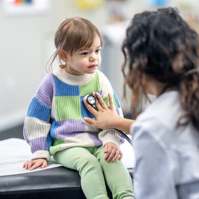 Provider listening to young patient's heart.