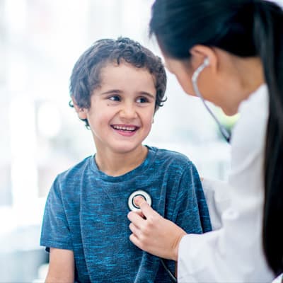 Doctor listening to young patients heart.