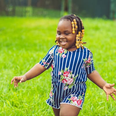 Young girl playing outside in the grass.