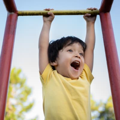 Young boy playing on playground.