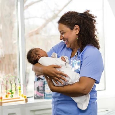 Nurse holding newborn baby.