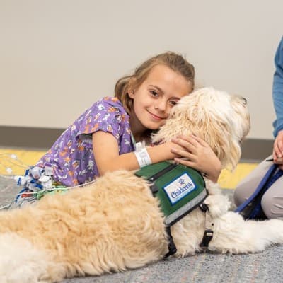 Young patient at Children's hugging the therapy dog.